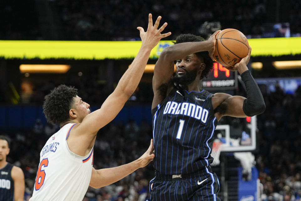 Orlando Magic's Jonathan Isaac (1) looks to pass the ball as New York Knicks' Quentin Grimes, left, defends during the second half of an NBA basketball game Tuesday, Feb. 7, 2023, in Orlando, Fla. (AP Photo/John Raoux)