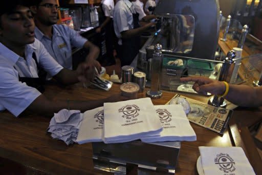 Baristas serve a customer at a Coffee Bean and Tea Leaf outlet in Mumbai on July 18. Starbucks is betting on big returns as it seeks to lure an expanding legion of coffee lovers in India -- primarily a tea-drinking nation where lifestyle changes have spawned a booming market for cafes