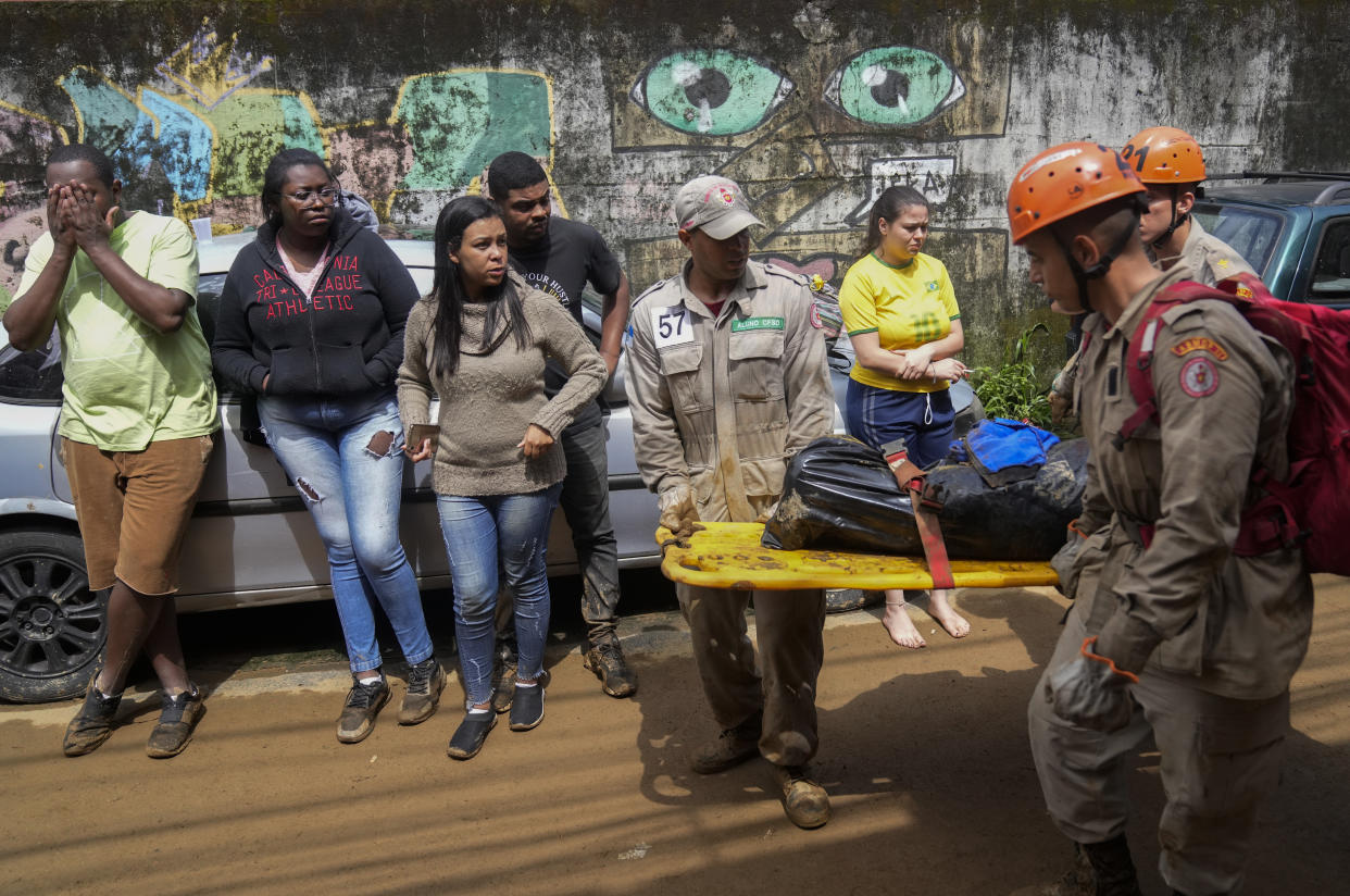 Rescue workers carry the body of a mudslide victim in Petropolis, Brazil, Wednesday, Feb. 16, 2022. Extremely heavy rains set off mudslides and floods in a mountainous region of Rio de Janeiro state, killing multiple people, authorities reported. (AP Photo/Silvia Izquierdo)