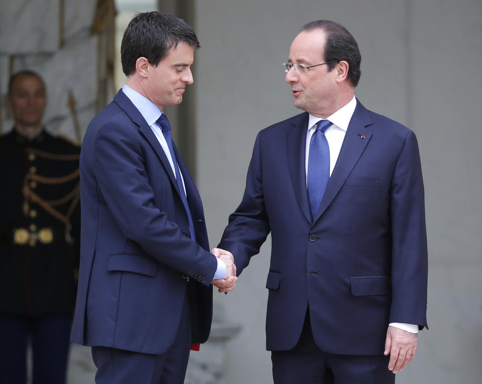 French President Francois Hollande, right, shakes hands with new French Prime Minister Manuel Valls after the first weekly cabinet meeting after municipal elections, at the Elysee Palace in Paris, Friday, April 4, 2014. President Francois Hollande shook up the government this week after his Socialist Party suffered an electoral defeat in nationwide municipal elections. Among two new faces in the Cabinet is Segolene Royal, a longtime politician and mother of Hollande's children, as environment and energy minister. (AP Photo/Michel Euler)