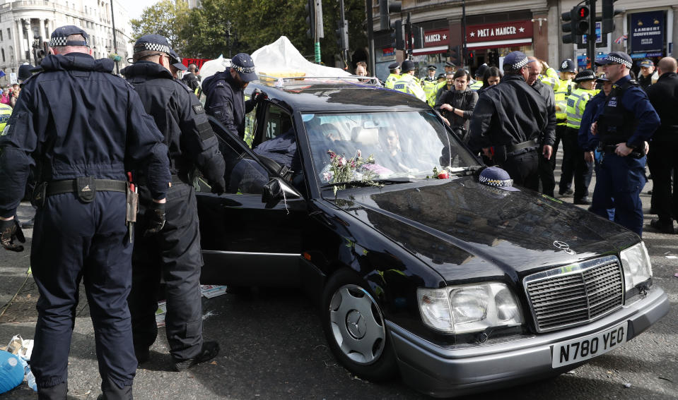 Climate change protesters are extracted and arrested from a hearse in Trafalgar Square in London, Thursday, Oct. 10, 2019. Some hundreds of climate change activists are in London during a fourth day of world protests by the Extinction Rebellion movement to demand more urgent actions to counter global warming.(AP Photo/Alastair Grant)