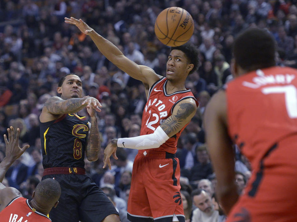 Cleveland Cavaliers guard Jordan Clarkson (8) passes the ball past Toronto Raptors forward Oshae Brissett (12) during first half NBA basketball action in Toronto on Monday, Dec. 16, 2019. (Nathan Denette/The Canadian Press via AP)