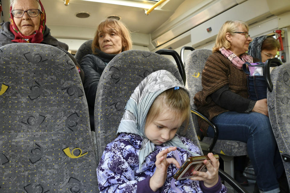 People sit in a bus during an evacuation of civilians on a road near Slovyansk, eastern Ukraine, Wednesday, May 4, 2022. (AP Photo/Andriy Andriyenko)