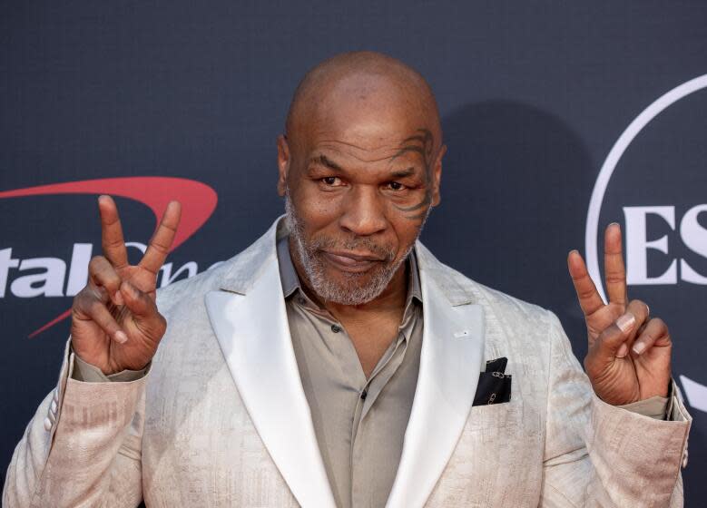 Mike Tyson gives peace signs with both hands as he arrives on the red carpet at the 2023 ESPY Awards.