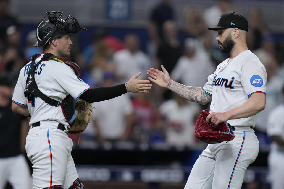 Miami Marlins catcher Nick Fortes (4) and relief pitcher Tanner Scott congratulate each other after the Marlins beat the Los Angeles Dodgers 6-3 during a baseball game, Tuesday, Sept. 5, 2023, in Miami. (AP Photo/Wilfredo Lee)