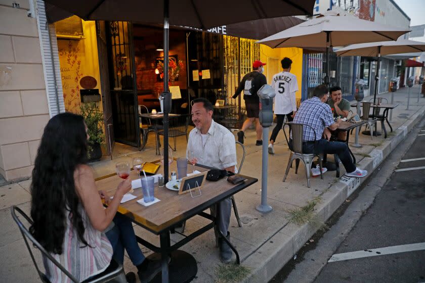 LOS ANGELES, CA - JULY 25: Veronica Nandino, left, and Camilo Cruz, both of Los Angeles, dine outdoors at Baracoa Cuban Cafe in Atwater Village on Saturday, July 25, 2020 in Los Angeles, CA. Restaurant on-site dining limited to outdoor seating due to Covid-19 restrictions in Southern California. Most of the tables are being set up on wide sidewalk areas, or in parking spaces adjacent to the restaurants. (Gary Coronado / Los Angeles Times)