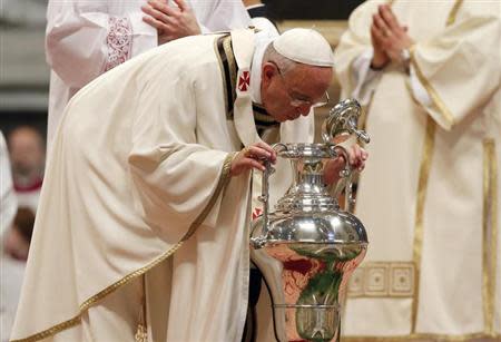 Pope Francis blows on blessed Chrism oil as he celebrates the Chrism Mass in Saint Peter's Basilica at the Vatican April 17, 2014. REUTERS/Stefano Rellandini