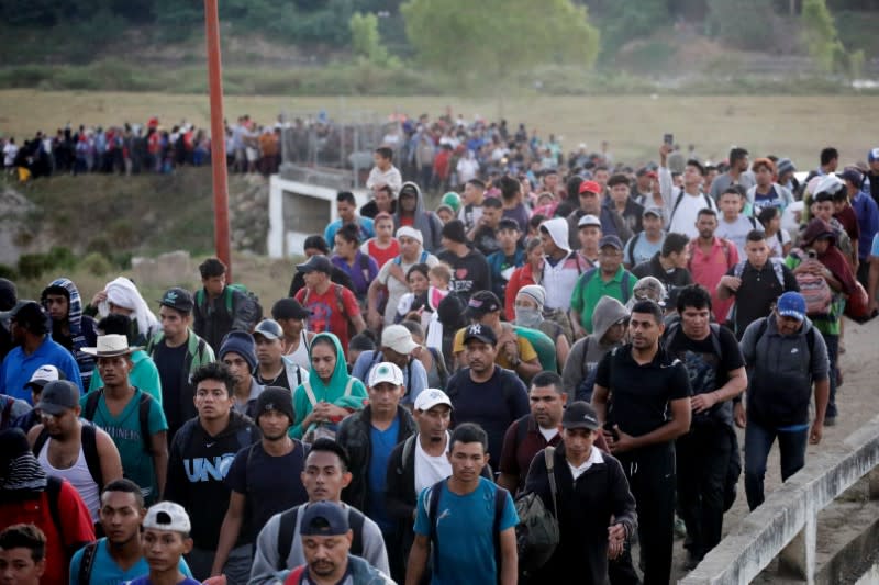 Migrants, mainly from Central America and marching in a caravan, walk after crossing the Suchiate river, on the outskirts of Ciudad Hidalgo