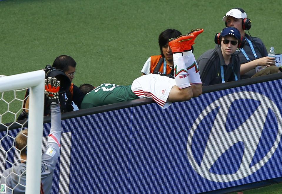 Mexico's Paul Aguilar falls into the photographers pit during the 2014 World Cup round of 16 game between Mexico and the Netherlands at the Castelao arena