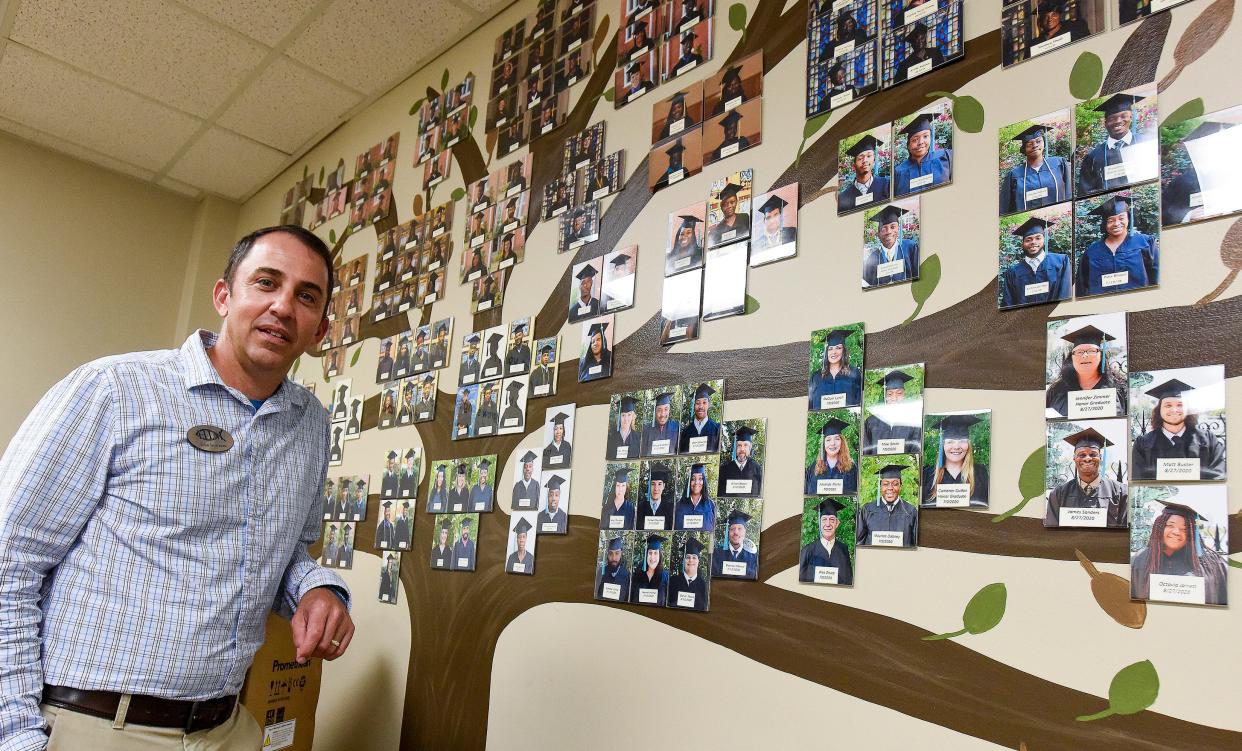 John Bowman, Executive Director of Hope inspired Ministries, stands beside a wall of photos of graduates of their program in Montgomery, Al., on Tuesday October 5, 2021. 
