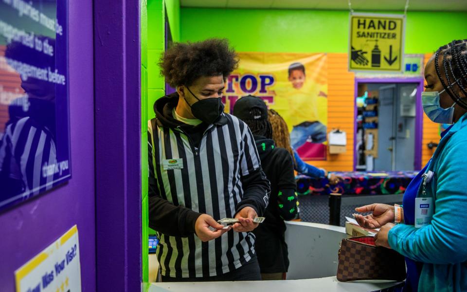 Terrence Hackett II (left), a junior at Ben Davis High School, assists a customer Wednesday, Feb. 16, 2022, during a school skate at Skateland on Indianapolis' west side.