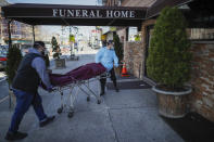 Employees deliver a body at Daniel J. Schaefer Funeral Home, Thursday, April 2, 2020, in the Brooklyn borough of New York. The company is equipped to handle 40-60 cases at a time. But amid the coronavirus pandemic, it was taking care of 185 Thursday morning. (AP Photo/John Minchillo)