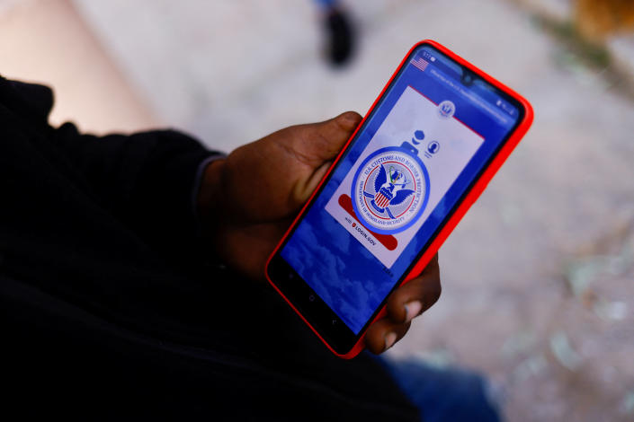 A migrant from Venezuela seeking asylum in the U.S. displays the U.S. Customs and Border Protection application on his phone.