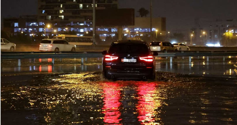 極端氣候也發生在中東地區，造成杜拜暴雨，圖為汽車駛過積水的路面。（圖／達志／路透社）