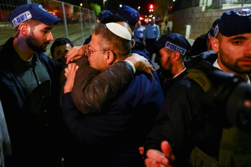 National security minister Itamar Ben-Gvir embraces a person while surrounded by Israeli forces near the scene of the shooting on Friday (REUTERS)