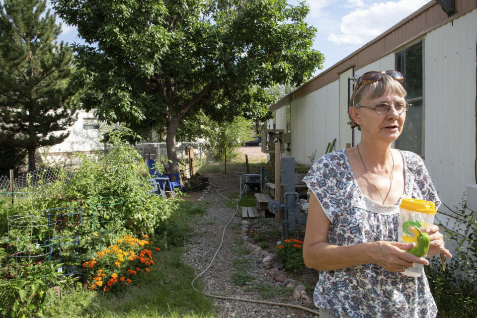 In this Sept., 4, 2019 photo Mobile home resident Linda Biggs walks near her home at Canyon Country mobile home park in Canon City, Colo., Some Colorado towns are taking action to preserve their remaining mobile home parks. Cities, counties and housing authorities, such as the Yampa Valley Housing Authority in Steamboat Springs, are buying mobile home parks to preserve affordable housing for residents as other mom-and-pop park owners sell out to developers or investors. (Jeremy Sparig/The Colorado Sun Via AP)