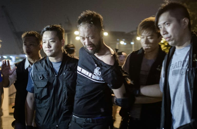 Civic Party member Ken Tsang, one of Hong Kong's pro-democracy political groups, is taken away by policemen, before being allegedly beaten up by police forces as seen on local TV footage shot outside the central government offices in Hong Kong