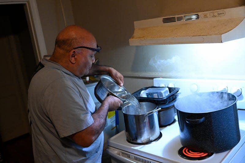 JACKSON, MS - DECEMBER 9: Charles Wilson III boils pots of water in his kitchen to use for his son’s Charles Wilson V bath on December 9, 2022 in Jackson, Mississippi. Wilson III says his son Wilson V started dinking tap water as a baby but switched to bottle water a year ago after he started suffering stomach problems and headaches. Jackson residents have been suffering from unsafe drinking water for years forcing people to use bottle water to drink, cook and brush their teeth. Flooding in August caused the water treatment facility to malfunction leaving residents without water to bathe or even flush toilets.