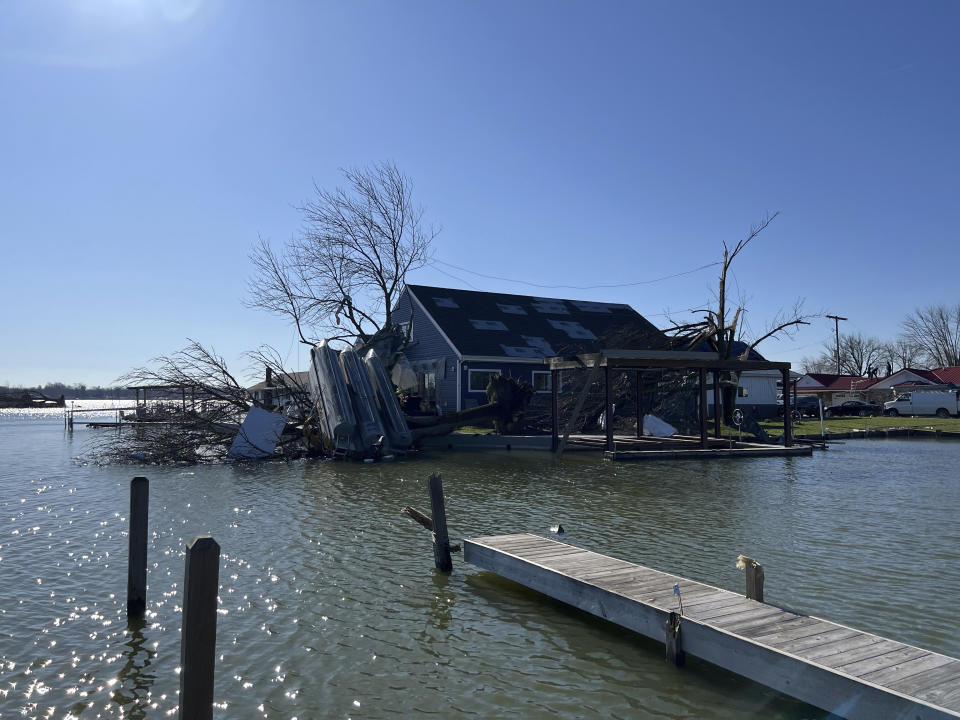 A boat sits upside down on a tree on Orchard Island in Russells Point, Ohio, on Saturday, March 16, 2024. Thursday night’s storms left trails of destruction across parts of Ohio, Kentucky, Indiana and Arkansas. (AP Photo/Patrick Orsagos)