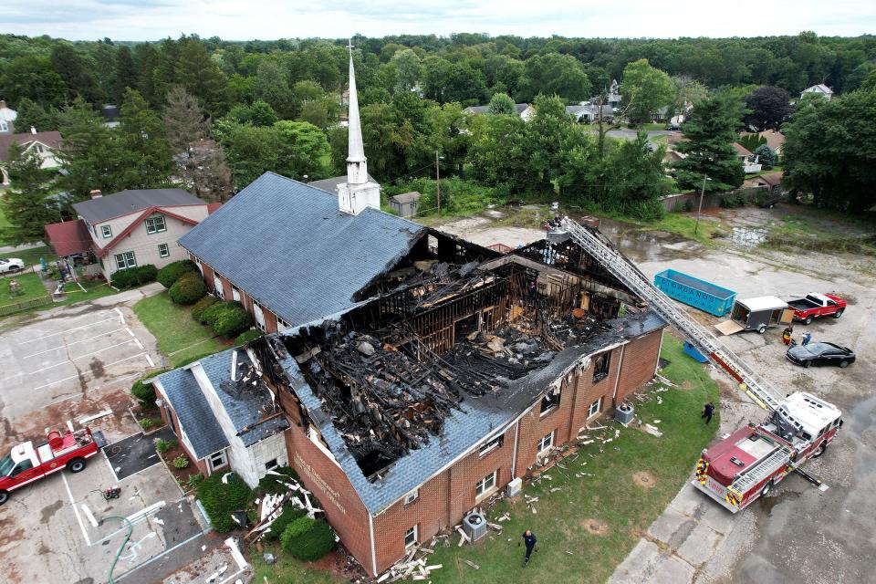 Firefighters conduct their investigation Tuesday afternoon, August 8, 2023, into the cause of a multi-alarm fire that heavily damaged the Voice of Deliverance New Covenant Evangelical Church on East Chestnut Avenue in Vineland.