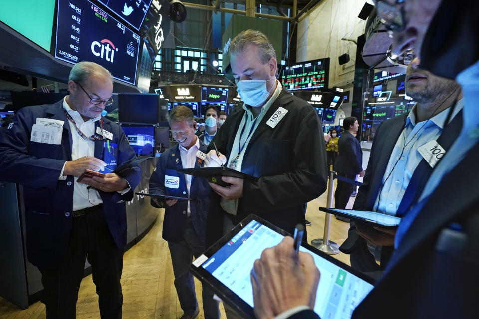 Traders gather at a post on the floor of the New York Stock Exchange, Tuesday, Aug. 3, 2021. Stocks are off to a mixed start on Wall Street as traders weigh another big set of company earnings reports, which have been coming in largely ahead of analysts&#39; forecasts. (AP Photo/Richard Drew)