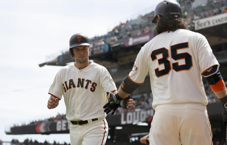 San Francisco Giants' Joe Panik is greeted by Brandon Crawford (35) after scoring the Giants' first run in the third inning of a baseball game against the Atlanta Braves Wednesday, Sept. 12, 2018, in San Francisco. Panik scored after the Giants' Evan Longoria singled to right field. (AP Photo/Eric Risberg)