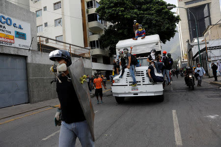 Demonstrators stand on a truck they want to use as a barricade while clashing with riot security forces during a rally against Venezuela's President Nicolas Maduro in Caracas, Venezuela, May 31, 2017. REUTERS/Carlos Garcia Rawlins