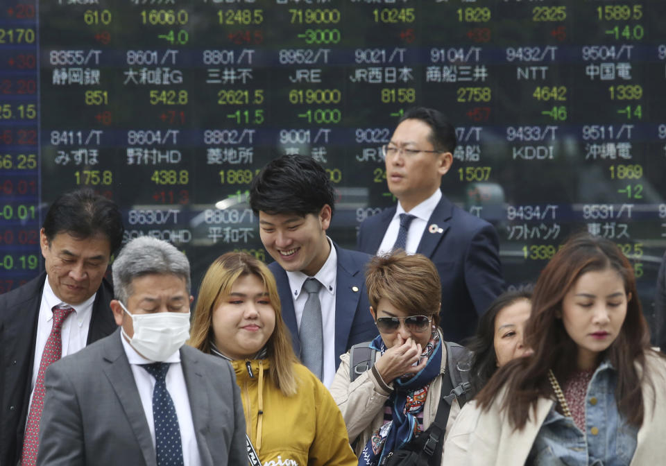 People stand in front of an electronic stock board of a securities firm in Tokyo, Wednesday, April 17, 2019. Shares were mixed in a narrow range Wednesday as China announced its economy grew at a 6.4 percent annual pace in the last quarter. (AP Photo/Koji Sasahara)