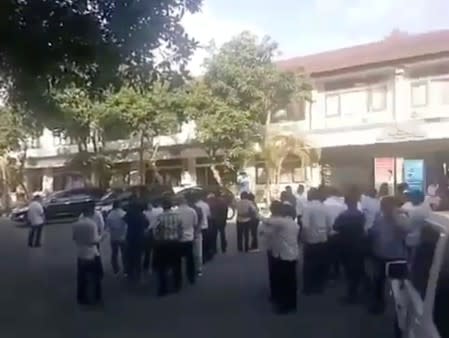 A crowd stands outside a building as an undersea quake struck south of Bali