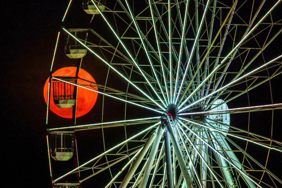 A super blue moon rises behind a ferris wheel located at Stokes Hill Wharf in Darwin, Australia on Aug. 31, 2023.<span class="copyright">David Gray—AFP/Getty Images</span>