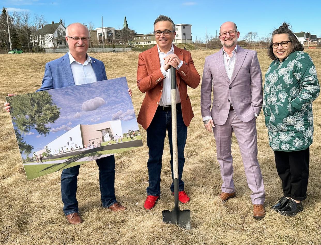 MLA John White, MP Mike Kelloway, Undercurrent Youth Centre's Trevor DenHartogh, and New Dawn CEO Erika Shea pose at the future site of the Glace Bay Youth and Family Centre. (Tom Ayers/CBC - image credit)