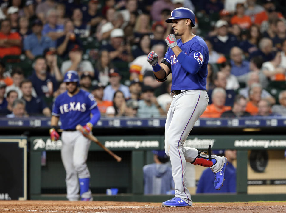Texas Rangers' Ronald Guzman, right, reacts as he crosses the plate on his home run during the eighth inning of the team's baseball game against the Houston Astros on Wednesday, Sept. 18, 2019, in Houston. (AP Photo/Michael Wyke)