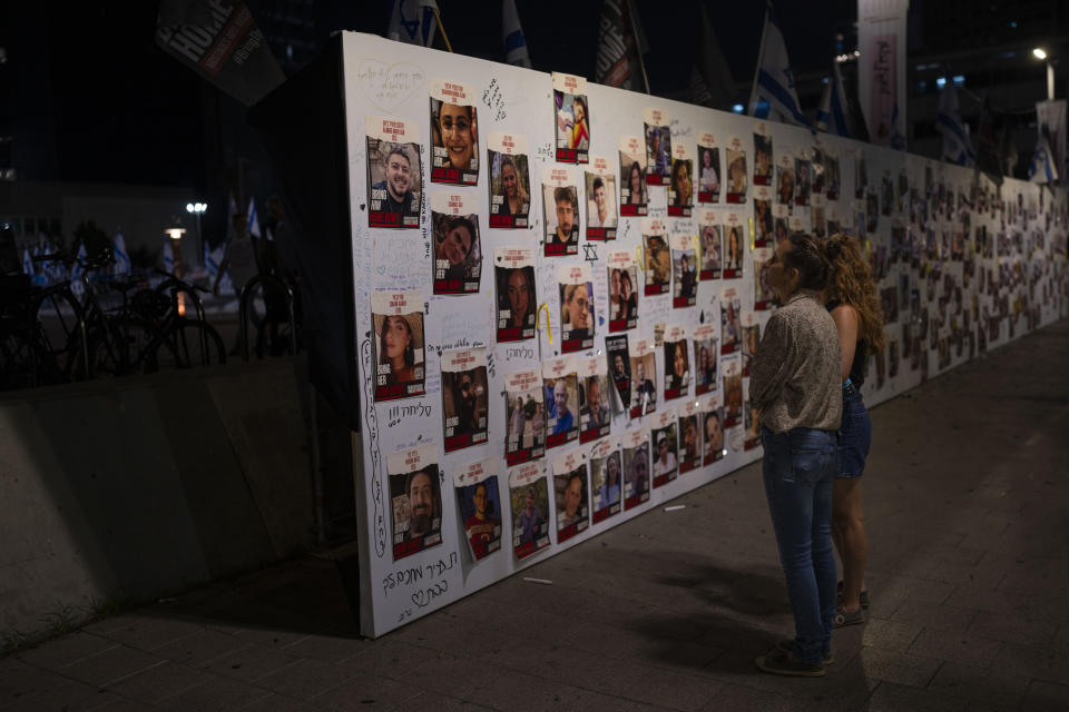 People look at a memorial for the more than 220 people captured by Hamas militants, in Tel Aviv, Israel, Saturday, Oct. 28, 2023. (AP Photo/Bernat Armangue)