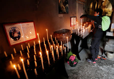 A contestant lights a candle in the St-Michel church before the start of the 16th Ultra-Trail du Mont-Blanc (UTMB) race in Chamonix, France August 31, 2018. REUTERS/Denis Balibouse