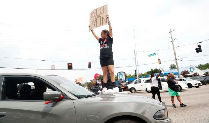 Atlanta resident Ashley McKenzie-Smith, the mother of Jaylin McKenzie, a 20-year-old who was killed after a December 2022 Memphis Police Department traffic stop, stands on the hood of a car at the intersection of American Way and S. Perkins Road Saturday afternoon.  The disruption, as she called it, was to raise awareness of her continued calls for transparency after her son died while visiting family in Memphis last year.