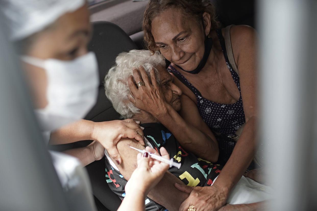 An elderly woman gets a shot of China's Sinovac CoronaVac vaccine as part of a priority COVID-19 vaccination program for the elderly at a drive-thru vaccination center in Rio de Janeiro, Brazil, Monday, Feb. 1, 2021.