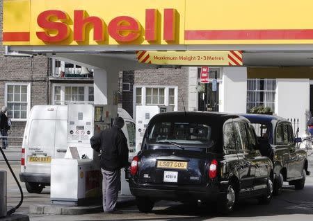 A taxi driver re-fuels his taxi at a Shell petrol station in London March 16, 2010. REUTERS/Luke MacGregor
