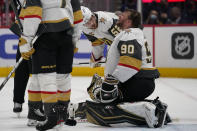 Vegas Golden Knights defenseman Dylan Coghlan (52) checks on Golden Knights goaltender Robin Lehner (90) after Lehner took a puck to the helmet during the second period of an NHL hockey game against the Washington Capitals, Monday, Jan. 24, 2022, in Washington. (AP Photo/Evan Vucci)