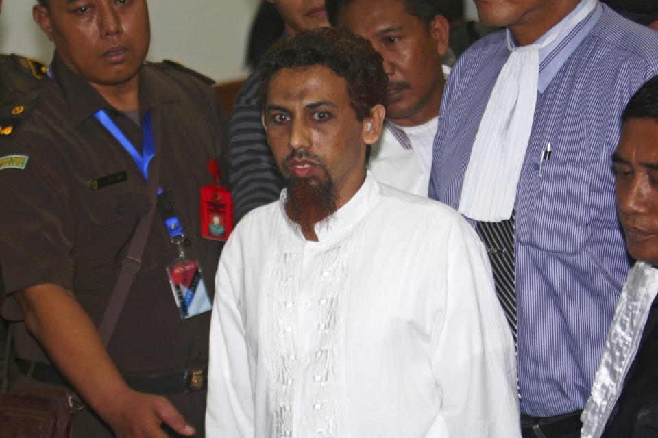 FILE - Indonesian Muslim militant Hisyam bin Alizein, center, better known by his alias Umar Patek, the bombmaker of a 2002 Bali bombing, is escorted by prosecutors and plain-clothed police officers as he leaves the courtroom after his hearing at West Jakarta district court in Jakarta, Indonesia, on May 21, 2012. In August 2022, Indonesia's government considered granting an early prison release to Patek, saying that he was an example of successful efforts to reform convicted terrorists and that they planned to use him to influence others not to commit terrorist acts. (AP Photo/Tatan Syuflana, File)