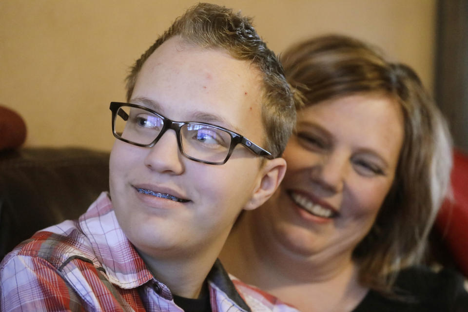 Dex Rumsey, 15, is photographed with his mother Robyn Friday, Jan. 17, 2020, in Roy, Utah. Dex Rumsey, 15, of Roy, Utah, came out as transgender at age 12. In consultation with a counselor and doctors, he gradually began wearing short hair and boy's clothes, then began using puberty blockers and eventually testosterone. His parents say he's gone from a shy, withdrawn child to a happy, thriving kid. He scared he could become depressed and suicidal again a ban on hormone therapy and sex-reassignment surgery for minors were to pass. (AP Photo/Rick Bowmer)