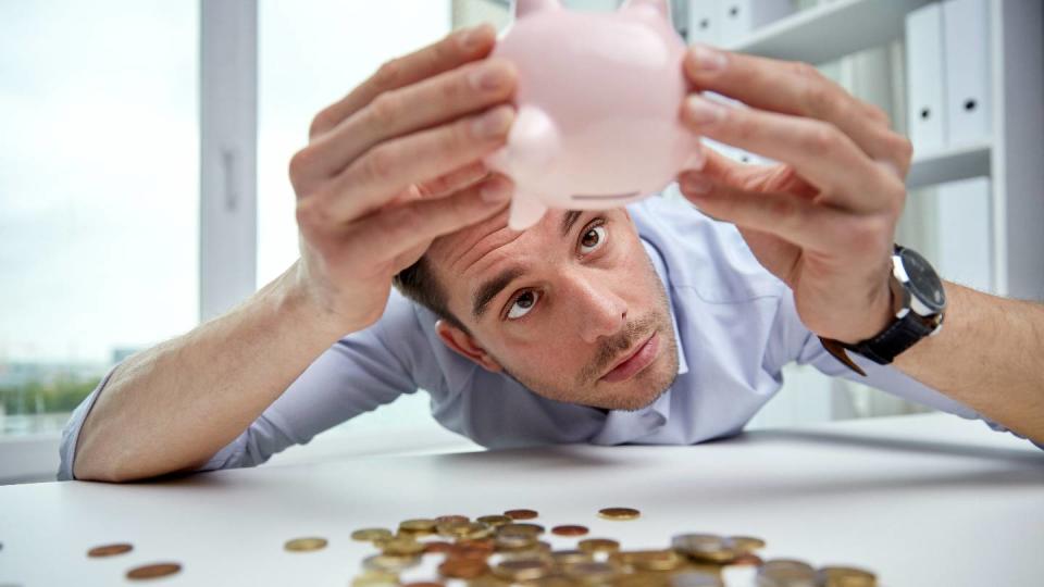 Un homme dans un bureau vide sa tirelire