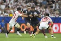 England's Maro Itoje, centre drives forward during the Rugby World Cup Pool D match between England and Japan in the Stade de Nice, in Nice, France Sunday, Sept. 17, 2023. (AP Photo/Pavel Golovkin)