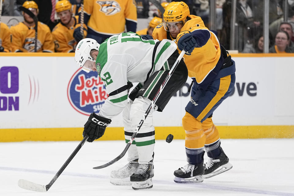 Dallas Stars center Radek Faksa, left, and Nashville Predators right wing Luke Evangelista (77) chase a loose puck during the first period of an NHL hockey game Saturday, Dec. 23, 2023, in Nashville, Tenn. (AP Photo/George Walker IV)