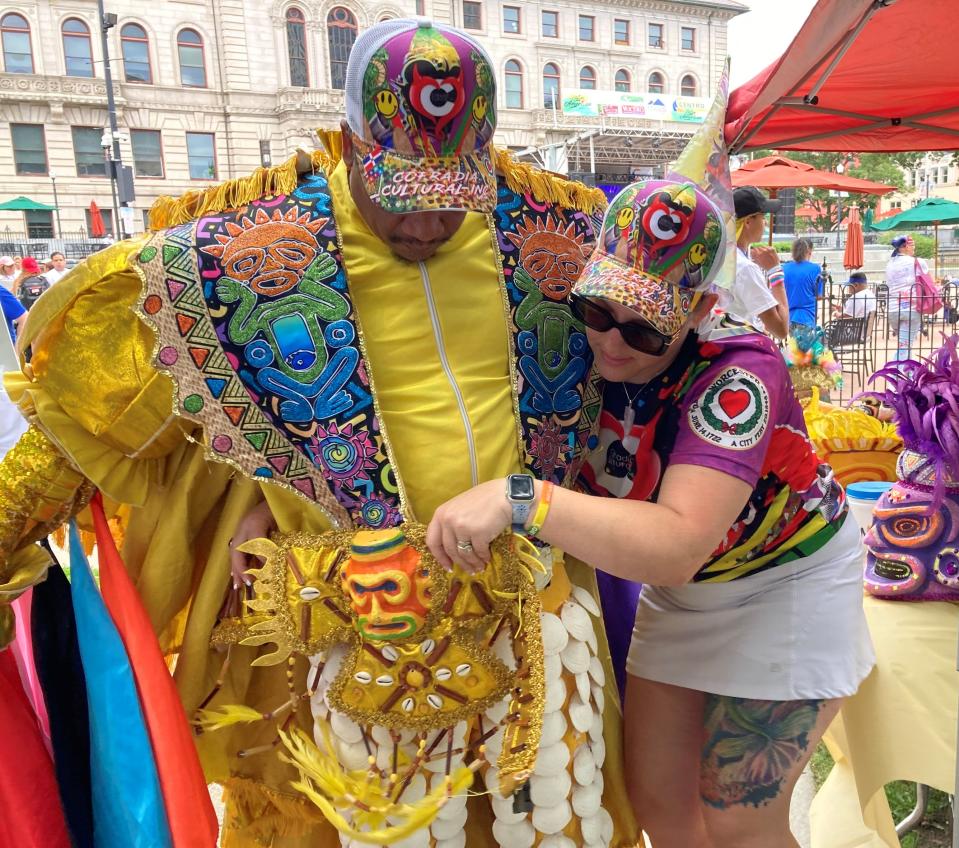 Holly Montero helps her husband, Edson Montero, a District 5 candidate for Worcester City Council, don the colorful costume representing the people of Puerto Plata in the Dominican Republic Saturday at the Latin American Festival in Worcester.