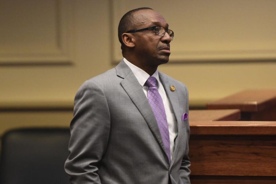 A man in a gray suit and purple tie