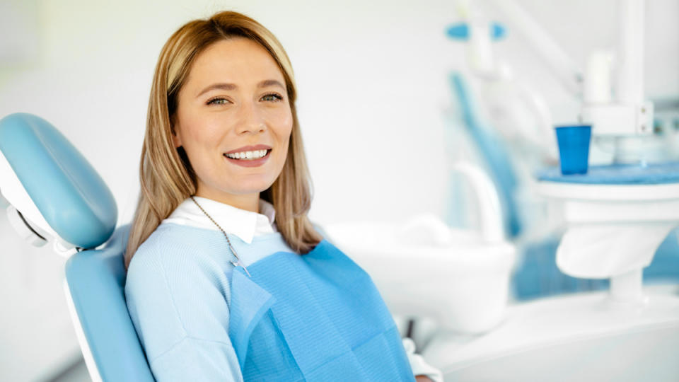 A woman in a dentists' chair to have her white gums examined