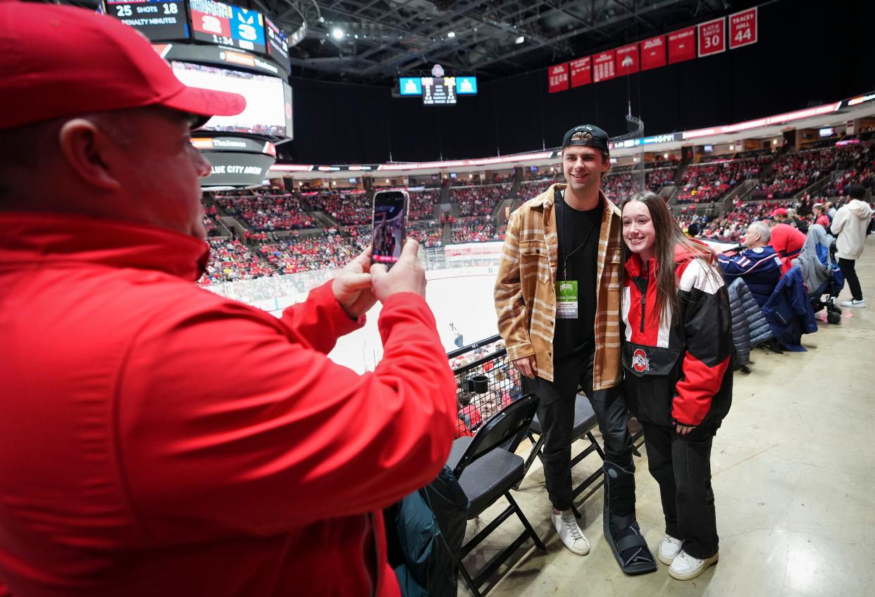 Feb 2, 2024; Columbus, Ohio, USA; Justin Hogan of Marysville take a photo of his daughter, Hanna Hogan, an Ohio State student with Columbus Blue Jackets forward Adam Fantilli during the NCAA men’s hockey game against the Ohio State Buckeyes at Value City Arena. Fantilli was at the game to watch his brother, Michigan defenseman Luca Fantilli along with his former Wolverine teammates, play the Buckeyes.