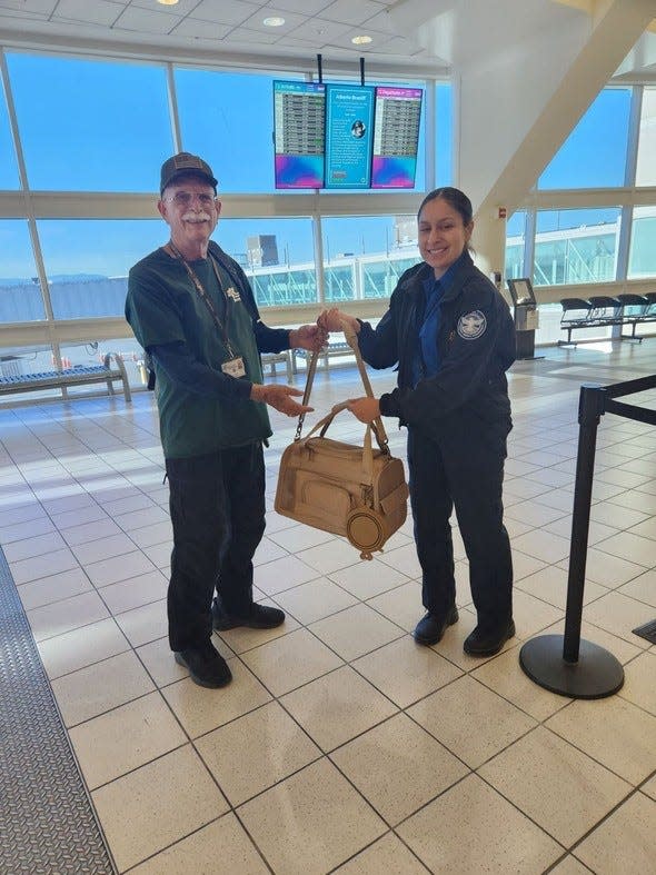 Animal Services volunteer Larry Rudolph holds a cat named Butters in a bag before their flight from Ontario International Airport.