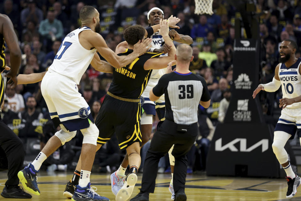 Minnesota Timberwolves forward Jaden McDaniels, back and Golden State Warriors guard Klay Thompson, front, get into an altercation during the first half of an in-season NBA tournament basketball game in San Francisco, Tuesday, Nov. 14, 2023. They were both ejected from the game. (AP Photo/Jed Jacobsohn)