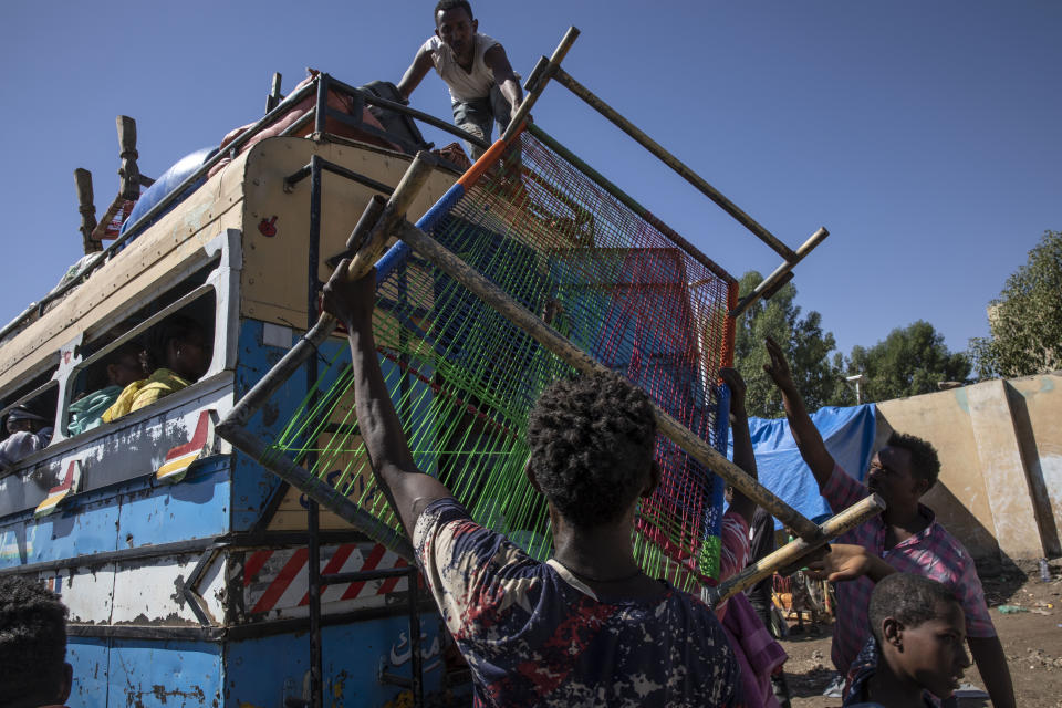 Tigray refugees who fled the conflict in the Ethiopia's Tigray put their furniture on top of a bus going to Village 8 temporary shelter, near the Sudan-Ethiopia border, in Hamdayet, eastern Sudan, Tuesday, Dec. 1, 2020. (AP Photo/Nariman El-Mofty)